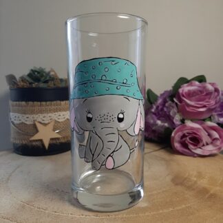 Verre haut transparent avec un éléphant gris peint à la main portant un chapeau bleu à pois, création artisanale Aleco en Vendée.