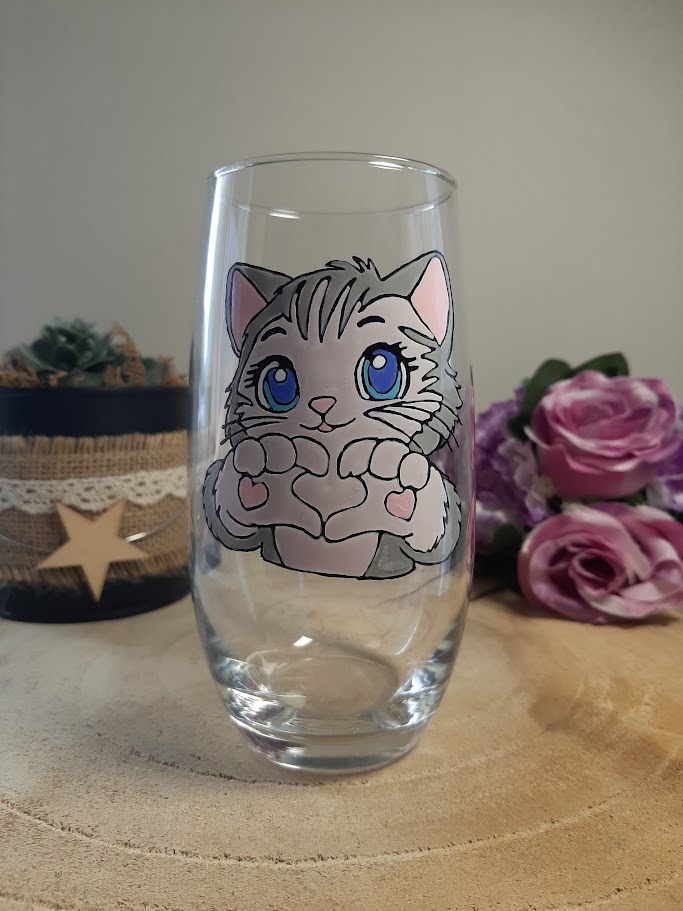 Verre haut avec un petit chat gris aux grands yeux bleus peint à la main, formant un cœur avec ses pattes, artisanat de Vendée Aleco.