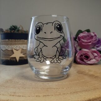 Verre gobelet transparent arrondi avec l'illustration d'une petite grenouille souriante peinte à la main en noir, style graphique épuré, artisanat Aleco Vendée.