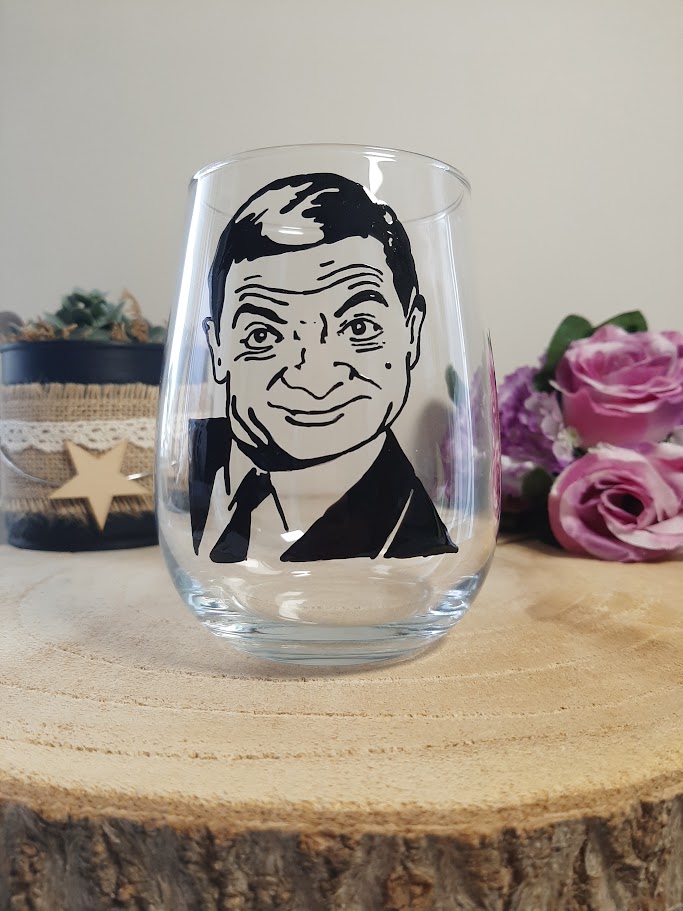 Verre gobelet arrondi avec le portrait de Mr Bean (Rowan Atkinson) peint à la main en noir, style graphique expressif, artisanat de Vendée Aleco.