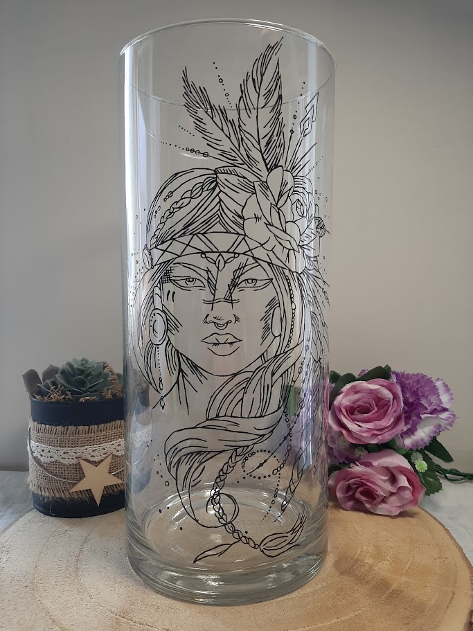 Grand vase cylindrique transparent avec le portrait détaillé d'une femme amérindienne portant une coiffe de plumes et une fleur, peint à la main en noir, artisanat Aleco.