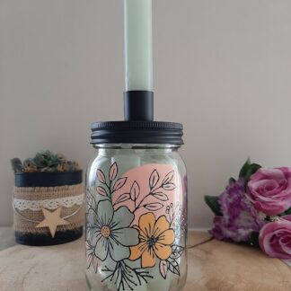 Bougeoir bocal en verre avec couvercle noir et bougie blanche, décoré de grandes fleurs stylisées dans les tons vert d'eau, orangé et rose pastel, peint à la main, artisanat Aleco.