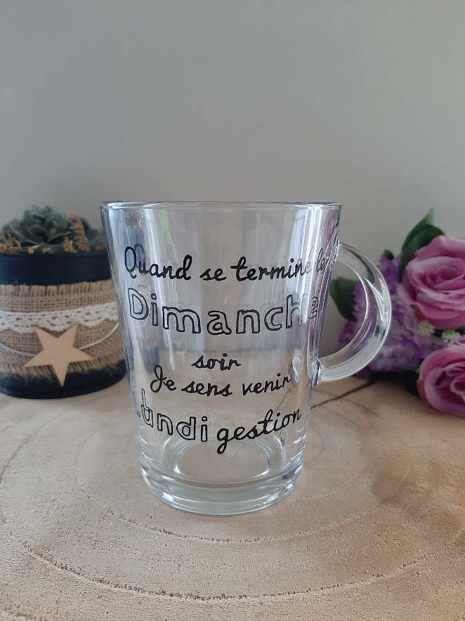 Mug en verre transparent avec anse, portant l'inscription humoristique calligraphiée à la main en noir : "Quand se termine le Dimanche soir Je sens venir Lundi gestion", artisanat Aleco.