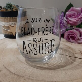 Gobelet en verre transparent de forme arrondie, peint à la main avec l'inscription en noir : "Je suis un BEAU-FRÈRE qui ASSURE", artisanat Aleco.