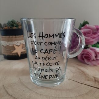 Mug en verre transparent avec anse, décoré d'une citation humoristique peinte à la main en noir : "LES HOMMES C'EST COMME LE CAFÉ ! AU DÉBUT ÇA T'EXCITE ET APRÈS ÇA T'ÉNERVE.", artisanat Aleco.