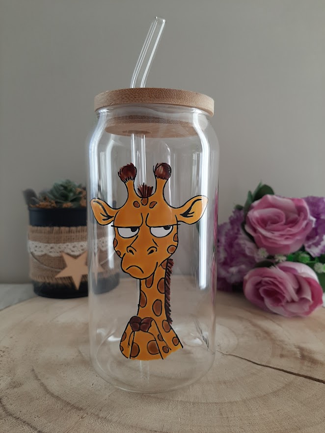 Gobelet en verre transparent avec couvercle en bambou et paille en verre, décoré d'une illustration artisanale d'une girafe à l'air blasé et mécontent, les bras croisés sur le torse, peinte à la main par Aleco.