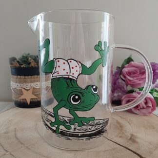 Pichet en verre artisan Aleco avec une grenouille verte peinte à la main faisant du surf en culotte à pois rouges.