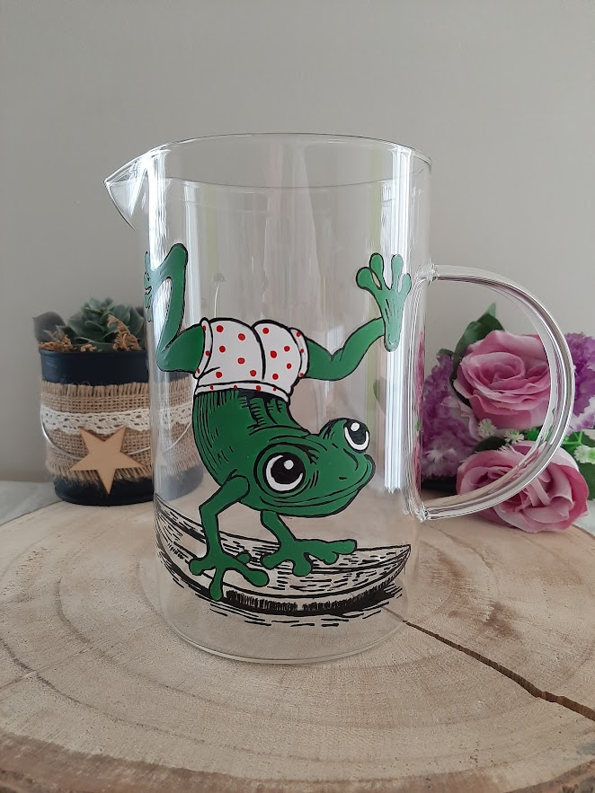 Pichet en verre artisan Aleco avec une grenouille verte peinte à la main faisant du surf en culotte à pois rouges.