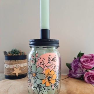 Bocal en verre transformé en bougeoir avec couvercle noir et bougie, peint à la main avec un motif floral orange et vert sauge