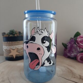 Verre canette transparent avec une vache humoristique qui bâille peinte à la main, couvercle bleu et paille en verre.