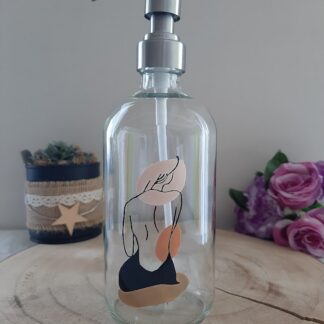 Distributeur de savon en verre avec peinture artisanale d'une silhouette de femme de dos et formes abstraites dans des tons beige et terre cuite