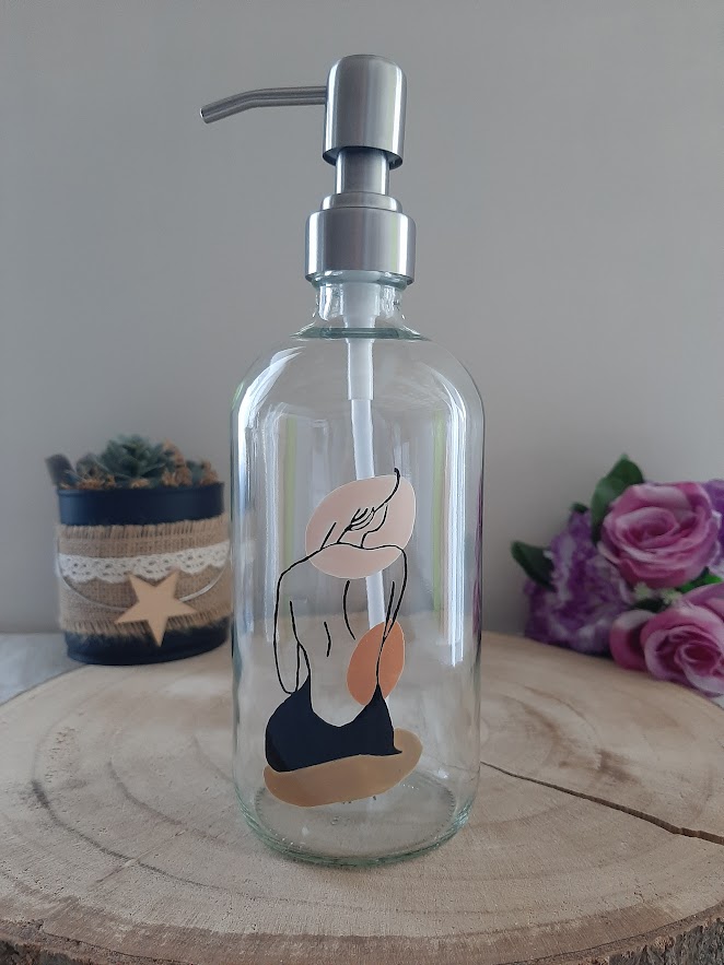 Distributeur de savon en verre avec peinture artisanale d'une silhouette de femme de dos et formes abstraites dans des tons beige et terre cuite