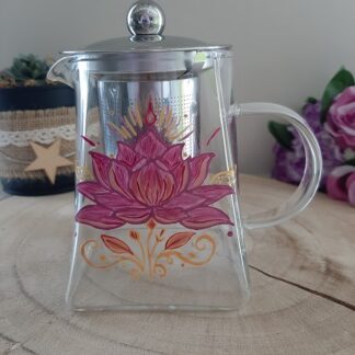 Grande théière en verre de 550ml avec peinture artisanale d'une fleur de lotus rose fuchsia et détails dorés rayonnants.