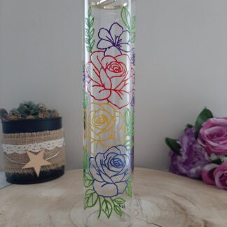 Porte-encens vertical en verre transparent avec peinture artisanale de roses stylisées aux contours rouge, jaune, bleu et violet.