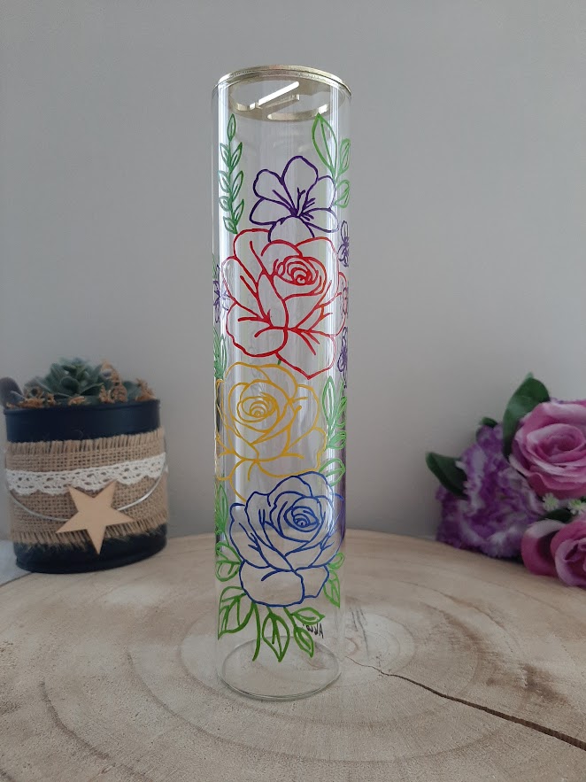 Porte-encens vertical en verre transparent avec peinture artisanale de roses stylisées aux contours rouge, jaune, bleu et violet.