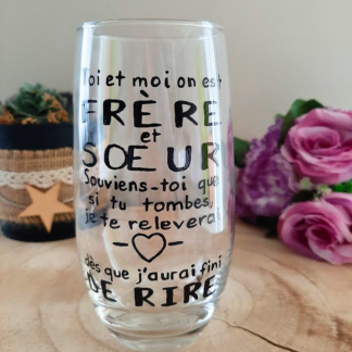 Verre haut transparent peint à la main levée avec une citation humoristique noire sur les frères et sœurs et un petit cœur, présenté sur un support en bois