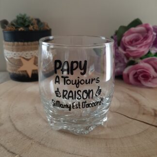 Verre à whisky transparent avec texte noir Papy a toujours raison si mamy est d'accord et illustrations de pouces levés.