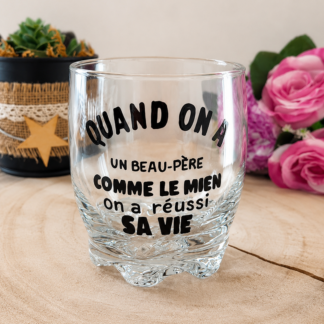 Verre taillé à message peint à la main « Quand on a un Beau-Père comme le mien on a réussi sa vie » posé sur une rondelle de bois avec des roses en arrière plan
