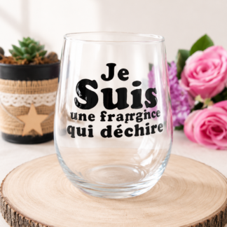 Verre à message peint à la main « Je Suis une Frangine qui Déchire » posé sur une rondelle de bois avec des roses roses et lilas en arrière plan