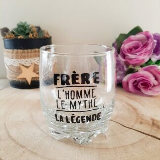 Verre taillé à message peint à la main « Frère L'homme Le Mythe La Légende » posé sur une rondelle de bois avec des roses en arrière plan