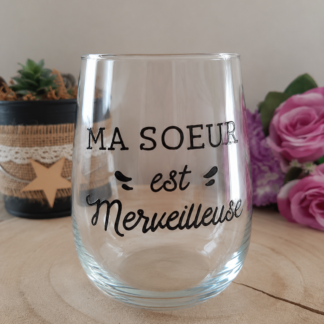 Verre à message peint à la main « Ma Sœur est Merveilleuse » avec typographie script élégante, posé sur une rondelle de bois avec des roses roses en arrière plan
