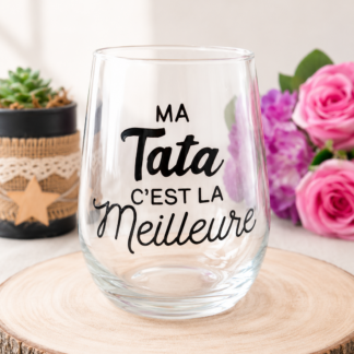 Verre à message peint à la main « Ma Tata c'est la Meilleure » posé sur une rondelle de bois avec des roses roses en arrière plan