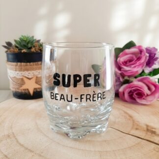 Verre taillé à message peint à la main « Super Beau-Frère » posé sur une rondelle de bois avec des roses roses en arrière plan