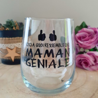 Gobelet en verre peint à la main avec inscription "Voici à quoi ressemble une maman géniale" et deux pouces levés noirs, posé sur une table en bois avec des roses roses