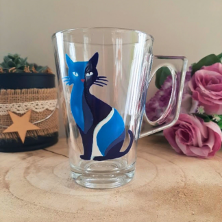 Mug en verre peint à la main avec chat bleu élégant, posé sur une table en bois