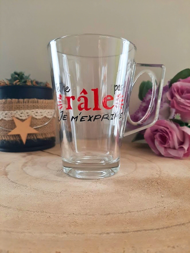 Mug en verre peint à la main avec message humoristique "Je ne râle pas, je m'exprime", posé sur une table en bois