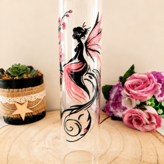 Porte-encens cylindrique en verre peint à la main avec fée aux ailes roses et fleurs de cerisier, cerclage doré, posé sur une table en bois avec des roses roses