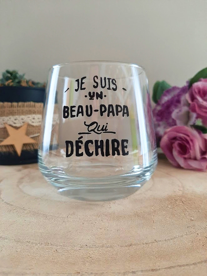 Verre à message peint à la main "Je suis un beau-papa qui déchire", posé sur une table en bois avec des fleurs roses
