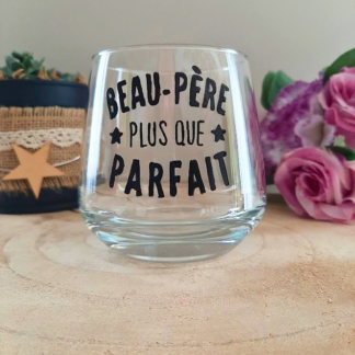 Verre à message peint à la main "Beau-père plus que parfait" avec petites étoiles, posé sur une table en bois avec des fleurs roses