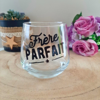 Verre à message peint à la main "Frère parfait" avec petite étoile, posé sur une table en bois avec des fleurs roses