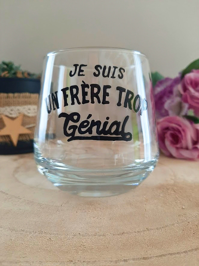 Verre à message peint à la main "Je suis un frère trop génial", posé sur une table en bois avec des fleurs roses