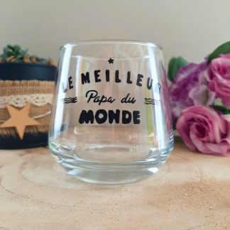 Verre à message peint à la main "Le meilleur papa du monde" style graphique avec vaguelettes, posé sur une table en bois avec des fleurs roses