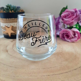 Verre à message peint à la main "Meilleur beau-frère" en calligraphie arquée, posé sur une table en bois avec des fleurs roses