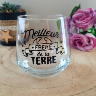 Verre à message peint à la main "Meilleur frère de la Terre" avec illustration de globe terrestre, posé sur une table en bois avec des fleurs roses