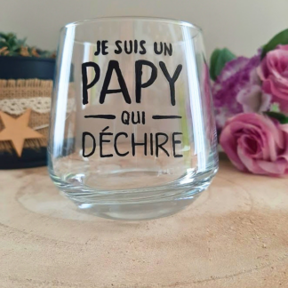 Verre à message peint à la main "Je suis un papy qui déchire", posé sur une table en bois avec des fleurs roses