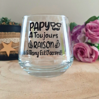 Verre à message humoristique peint à la main "Papy a toujours raison si Mamy est d'accord" avec illustrations lunettes et pouces levés, posé sur une table en bois avec des fleurs roses