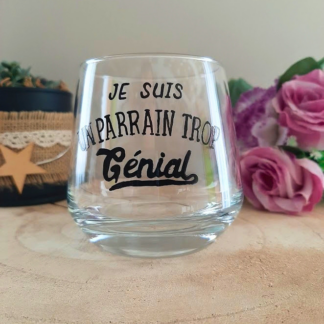 Verre à message peint à la main "Je suis un parrain trop génial", posé sur une table en bois avec des fleurs roses